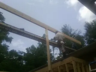 Carpenter setting a ridge beam over a new addition frame — Ice Dam Removal by Roofing Brothers in Little Compton