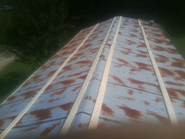 Rusted metal roof panels with new wood purlins before replacement — Storm Damage Roof Repair in Little Compton by Roofing Brothers
