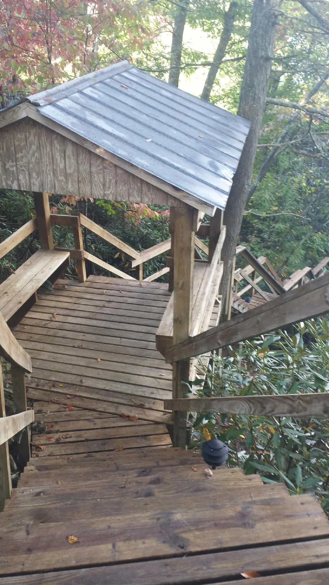 Metal roofed shelter over wooden steps on a wooded walkway — Skylight Repair & Installation work by our crew in Little Compton